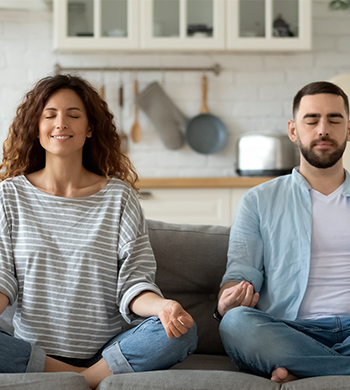 Family meditating on sofa